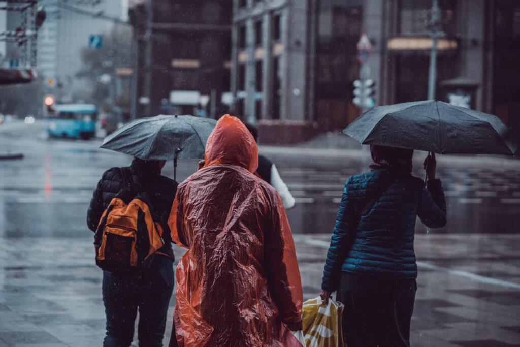 People walking in the rain, illustrating the importance of saving money for a rainy day.